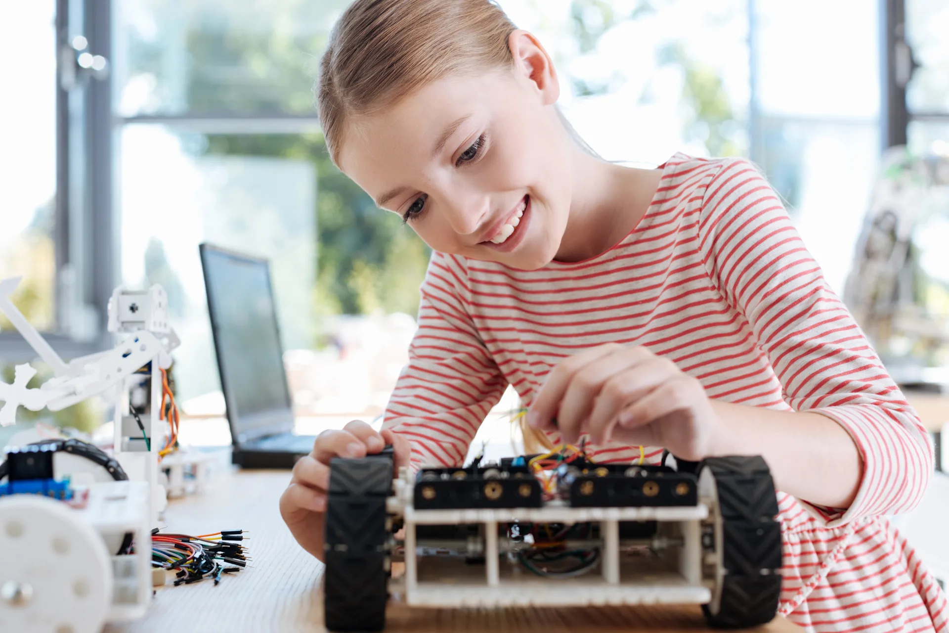 Girl building robot smiling at Love to Code Academy