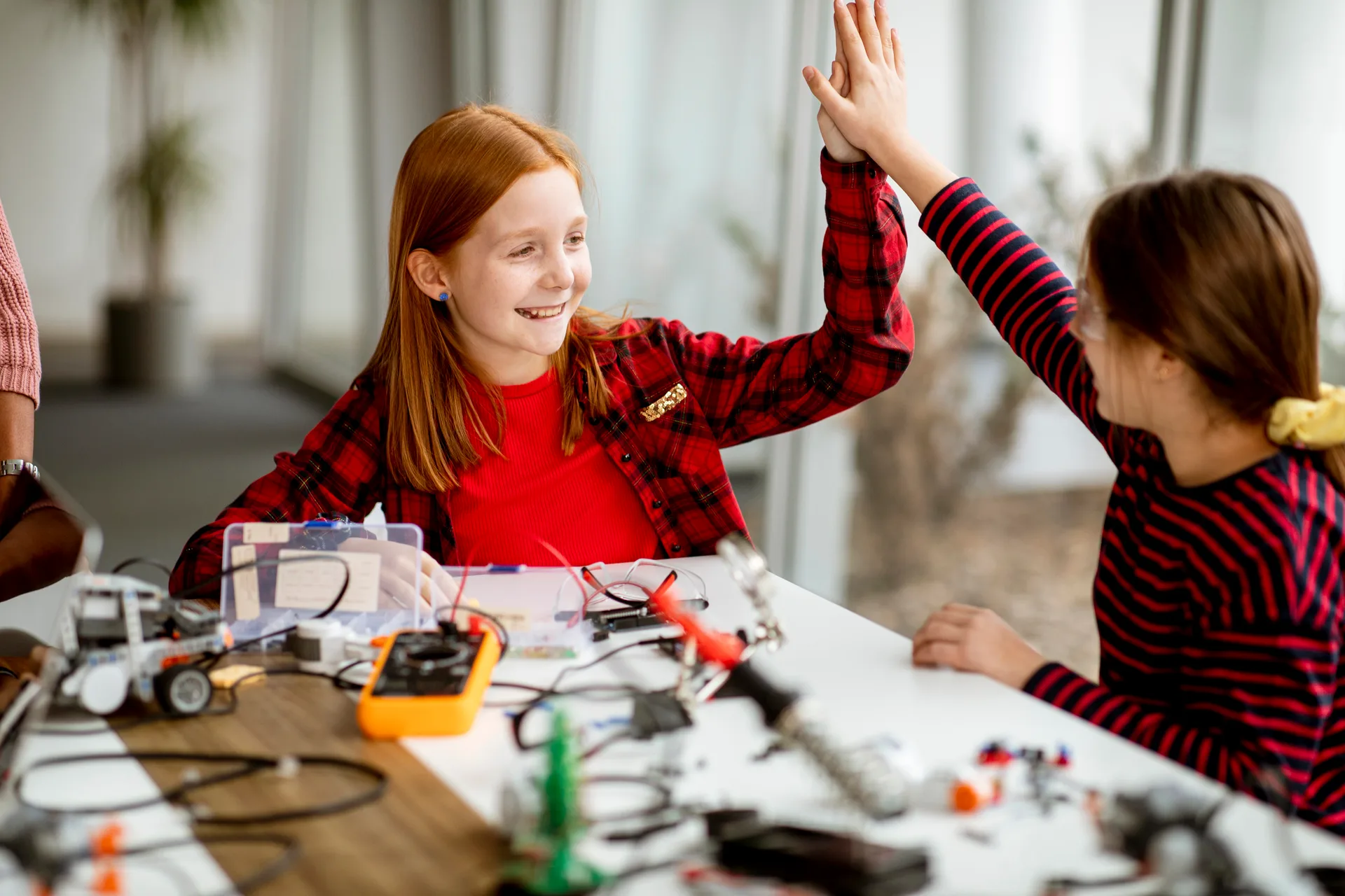 Girls high five robotics success at Love to Code Academy