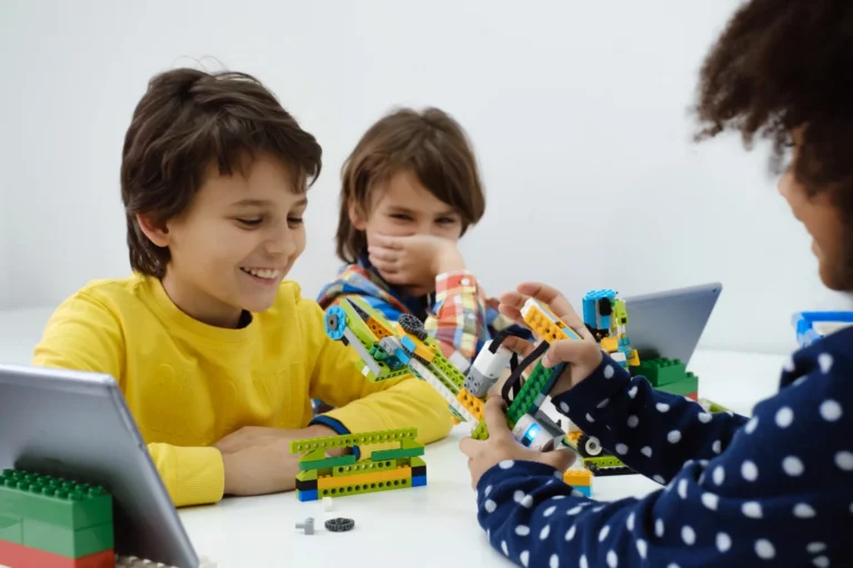 Students building LEGO WeDo smiling at Love to Code Academy