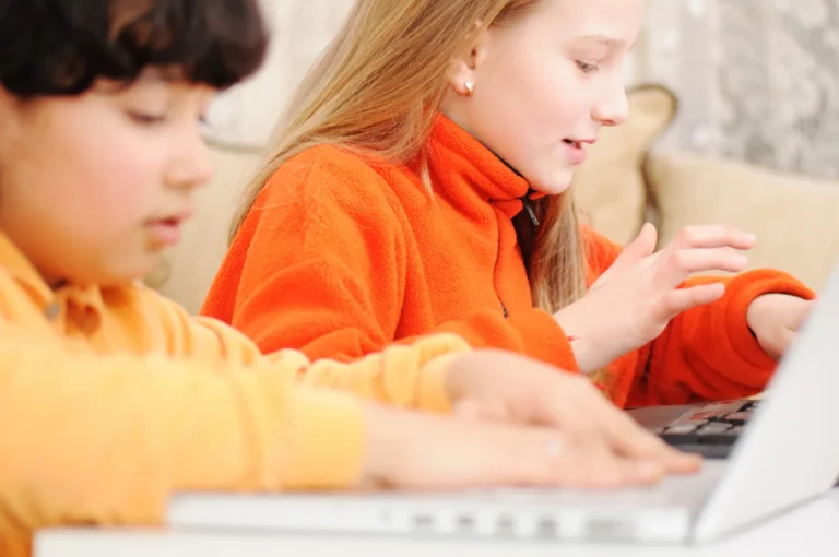 Students laptops orange sweaters at Love to Code Academy